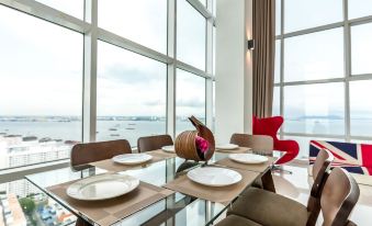 The living area features a dining room with large windows and a table for six, providing a scenic view at JK Maritime Luxury Suite
