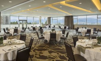 a large banquet hall with tables and chairs set up for a formal event , possibly a wedding reception at Element Vancouver Metrotown