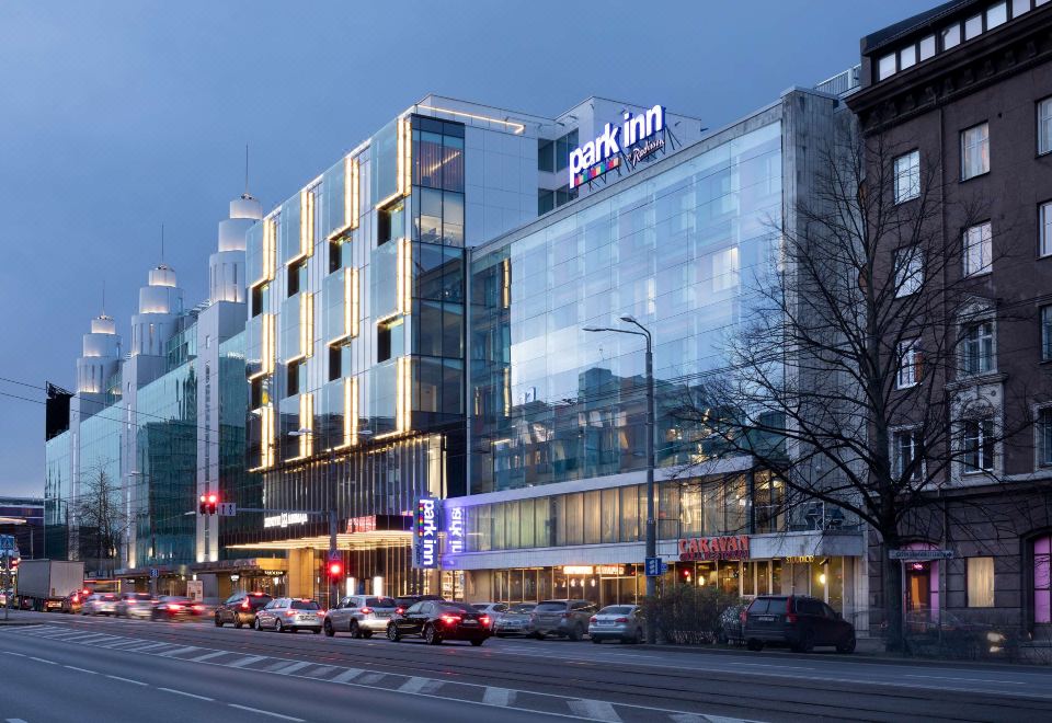 a city street with a tall building on the left side and a large hotel building on the right side at Park Inn by Radisson Central Tallinn