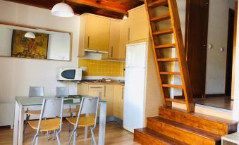 a kitchen with a wooden staircase leading to the second floor , where a dining table and chairs at Bellevue