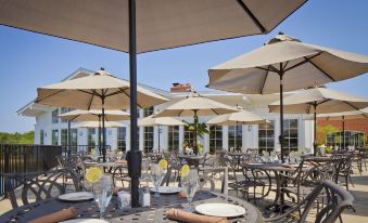an outdoor dining area with numerous umbrellas providing shade over the tables , creating a pleasant atmosphere at Nationwide Hotel and Conference Center