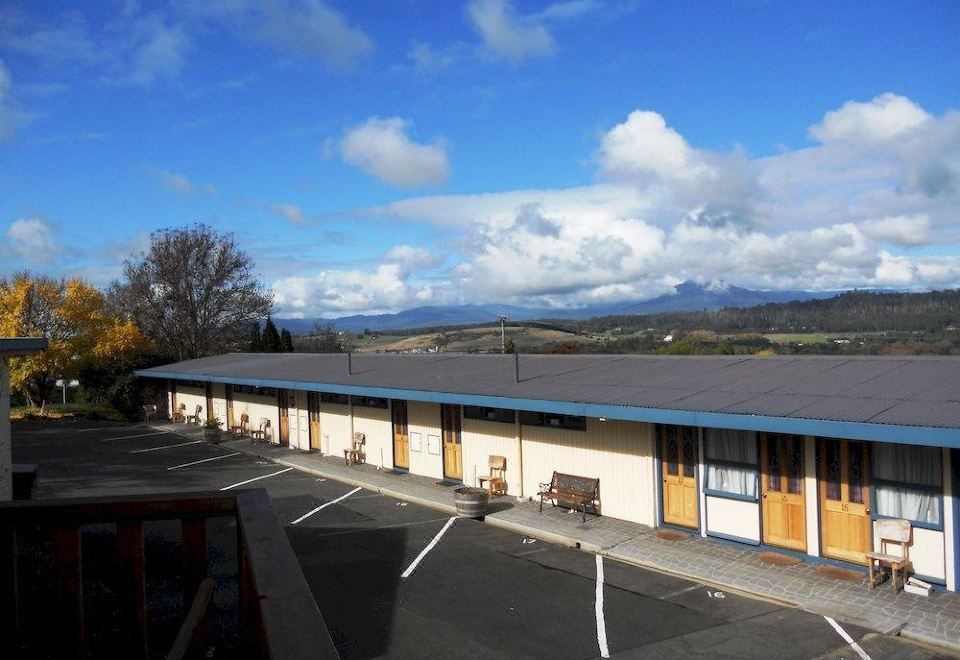 a parking lot with a row of buildings , one of which has a blue roof at Mountain View Country Inn