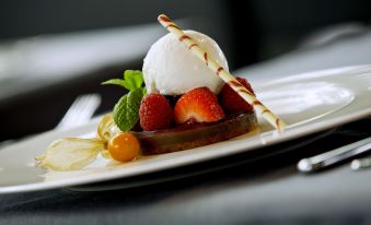 a dessert plate with a scoop of ice cream , strawberries , and other fruits on top at Renaissance Barcelona Fira Hotel