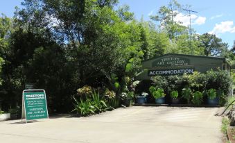 "a large sign for "" treetops art gallery "" is displayed in front of a lush green area with trees and plants" at Treetops Montville