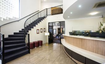 a modern office building with a staircase leading to the second floor , and a reception area on the ground floor at Coral Cay Resort