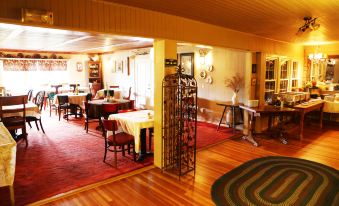 a dining room with a wooden floor and various chairs and tables , creating a cozy atmosphere at Grandview Lodge