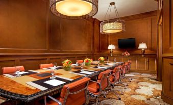 a conference room with a long table , chairs , and a tv mounted on the wall at 1 Hotel Hanalei Bay