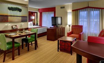 a hotel room with a king - sized bed , a dining table , a couch , a tv , and a dining table at Residence Inn Richmond Chester