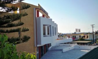 a modern building with a flat roof , surrounded by trees and other buildings in the background at Palladion