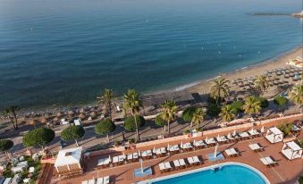 a bird 's eye view of a beachfront resort with a swimming pool and lounge chairs at El Fuerte Marbella