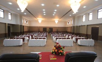 a large , empty banquet hall with multiple rows of tables and chairs set up for a formal event at Haile Resort Hawassa