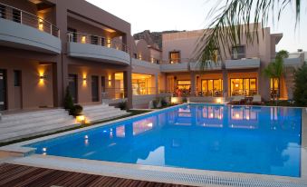 a large swimming pool is surrounded by a house and palm trees , with lights illuminating the area at Libyan Princess