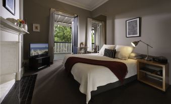 a large bedroom with a king - sized bed , a television , and a view of the outdoors at Athelstane House