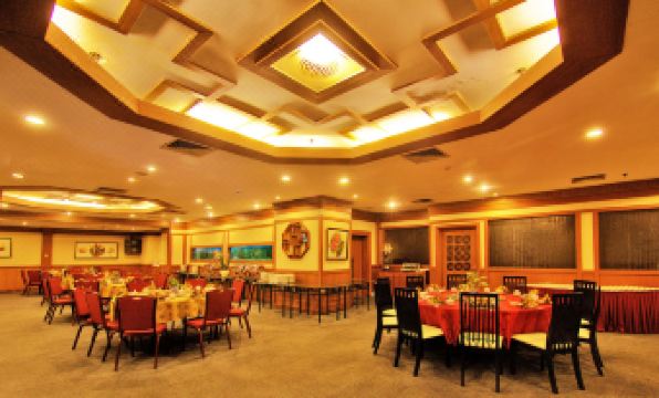 a large dining room with multiple tables and chairs arranged for a group of people to enjoy a meal together at Planet Holiday Hotel & Residence