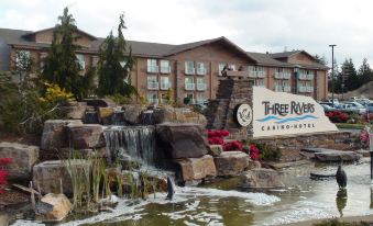 "a large building with a waterfall and the name "" three rivers casino & resort "" on it" at Three Rivers Casino Resort