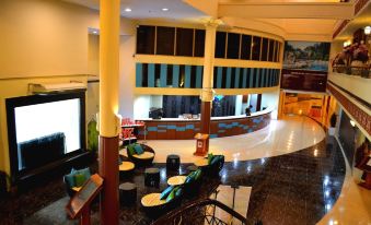 a hotel lobby with a large bar and several chairs , creating a comfortable and inviting atmosphere at De Rhu Beach Resort