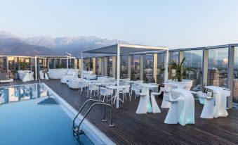 an outdoor dining area with tables and chairs , surrounded by a pool and the ocean at Icon Hotel