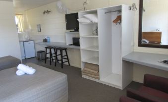 a small , tidy room with a bed , a kitchenette , and a tv . the room is clean and well - organized at Waterview Motel Maclean