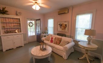 a cozy living room with a white couch , a coffee table , and a television mounted on the wall at Inn at Tyler Hill