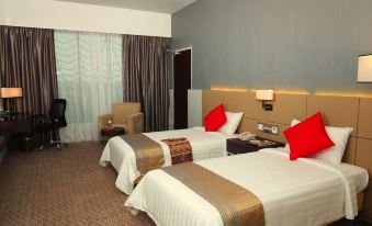 a hotel room with two beds , one on the left and one on the right side of the room at Raia Hotel & Convention Centre Alor Setar