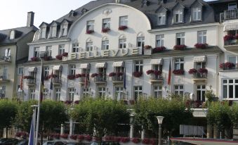 "a large white building with the word "" bellevue "" written on it , situated in a city street" at Bellevue Rheinhotel