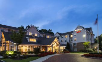 a fairfield inn hotel with its signature red brick exterior and large sign , set against a dark sky at Residence Inn Philadelphia Langhorne