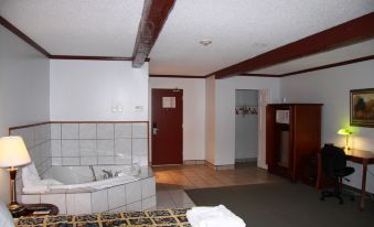 a hotel room with a bathtub in the corner and a door to another room at Causeway Bay Hotel