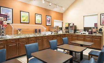 a hotel breakfast nook with a dining table and chairs , as well as a refrigerator and a microwave at Residence Inn Hartford Windsor