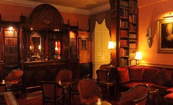 a cozy living room with a bar in the background , creating a warm and inviting atmosphere at Lumley Castle Hotel