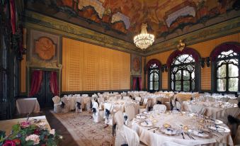 a large dining room with white tablecloths and chairs set up for a formal event at Hotel Villa Cornér Della Regina