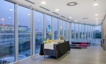 a table with a black cloth and various items is set up in a room with large windows at NH Orio Al Serio