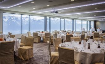 a large dining room with tables and chairs set up for a formal event , possibly a wedding reception at Le Mirador Resort and Spa