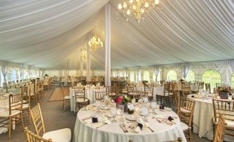 a large , white tent with multiple tables and chairs set up for a formal event at Castle Hill Resort and Spa