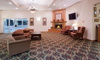 a spacious room with several couches , chairs , and a fireplace , creating a cozy and inviting atmosphere at Country Inn & Suites by Radisson, Sidney, NE