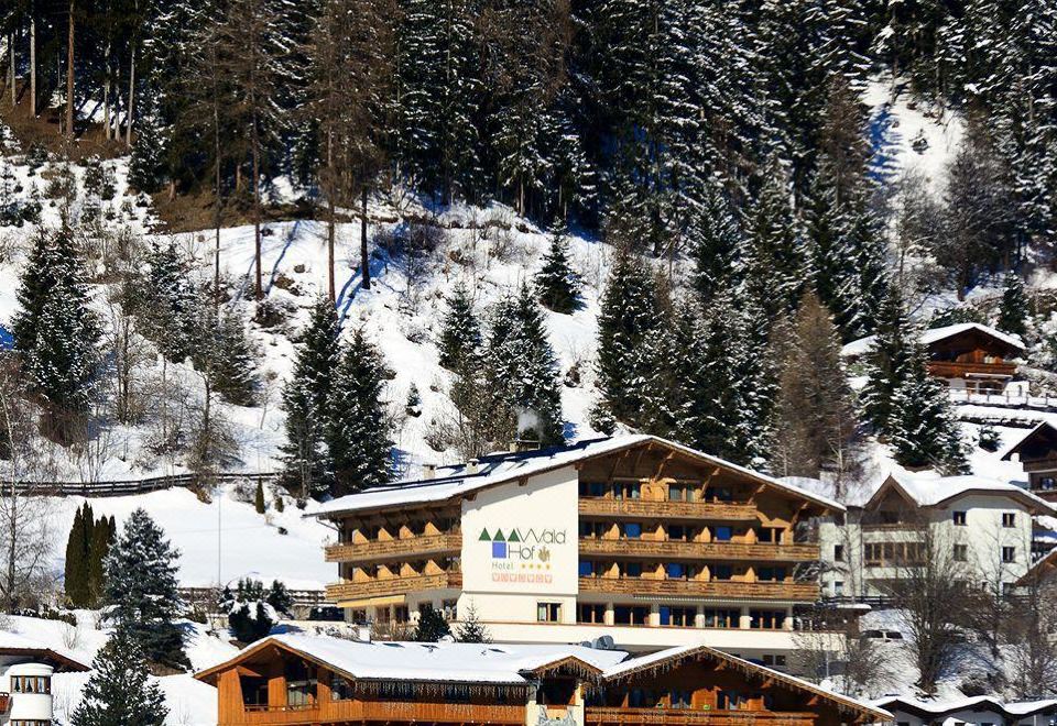 "a large building with a sign that says "" mirajore "" is surrounded by snow and trees" at Hotel Königsblick by Keyone