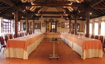a long dining table with orange and white tablecloths set up for a formal event at Hotel El Rancho