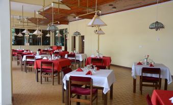 a large dining room with multiple tables and chairs arranged for a group of people to enjoy a meal together at Keys Hotel