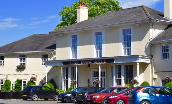 a row of cars parked in front of a large building , possibly a hotel or a restaurant at Alton House Hotel