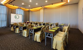 a conference room set up for a meeting , with chairs arranged in rows and a projector on the wall at Kip Hotel