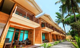 a row of wooden houses with balconies and a patio area in front of them at Pearl Sands of Maldives