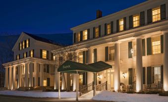 a large building with a green awning is lit up at night , surrounded by snow at The Equinox