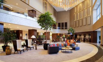 a large hotel lobby with multiple couches , chairs , and tables arranged for guests to relax and socialize at Sheraton Grand Samsun Hotel