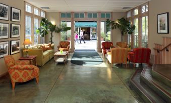 a large , well - lit room with multiple couches and chairs arranged in a comfortable seating area at Southbridge Napa Valley