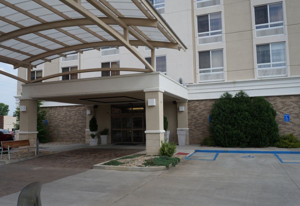 a large hotel entrance with a covered walkway and potted plants , set against the backdrop of a brick building at Holiday Inn Portsmouth Downtown