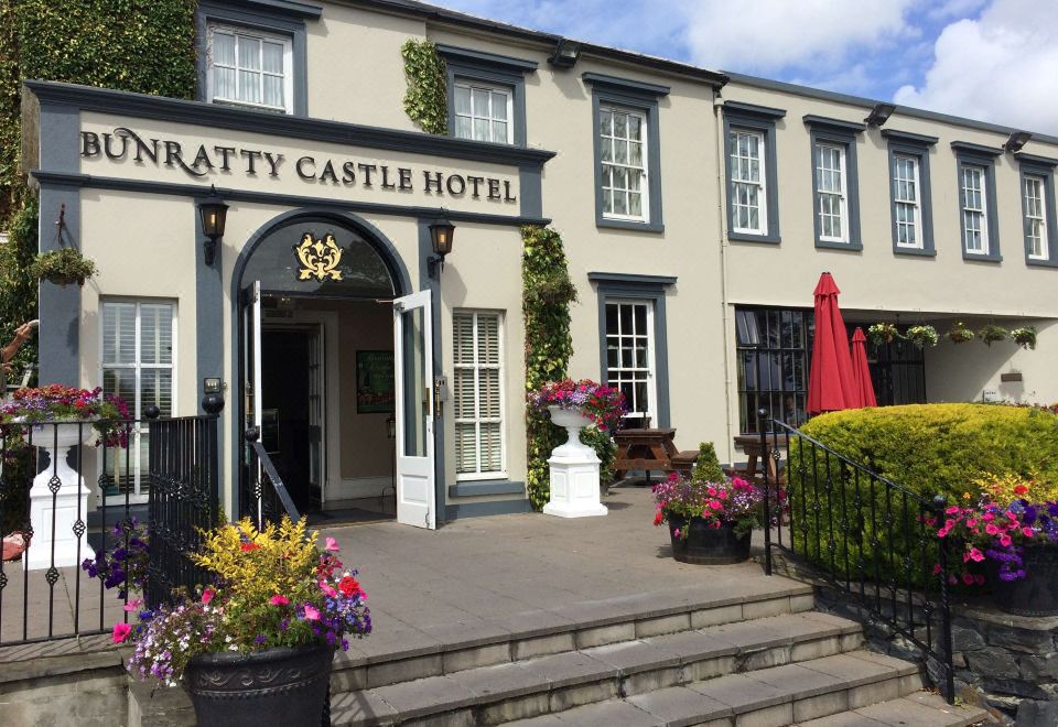 "the entrance to a hotel named "" the brathay castle hotel "" with flowers and umbrellas in front" at Bunratty Castle Hotel