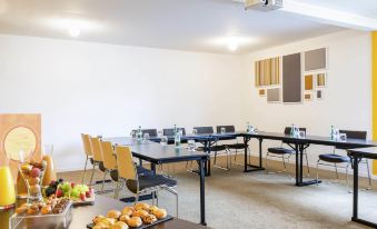 a conference room with a long table , chairs , and various food items on the table at Novotel le Mans