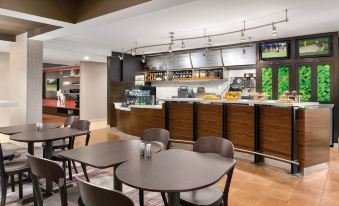 a modern restaurant with a dining area and a bar , featuring a variety of seating options at Courtyard Dayton North