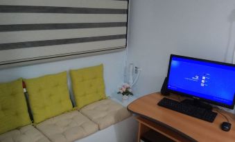 a small room with a bed , a desk , and a computer monitor on top of it at Like Home Gedera