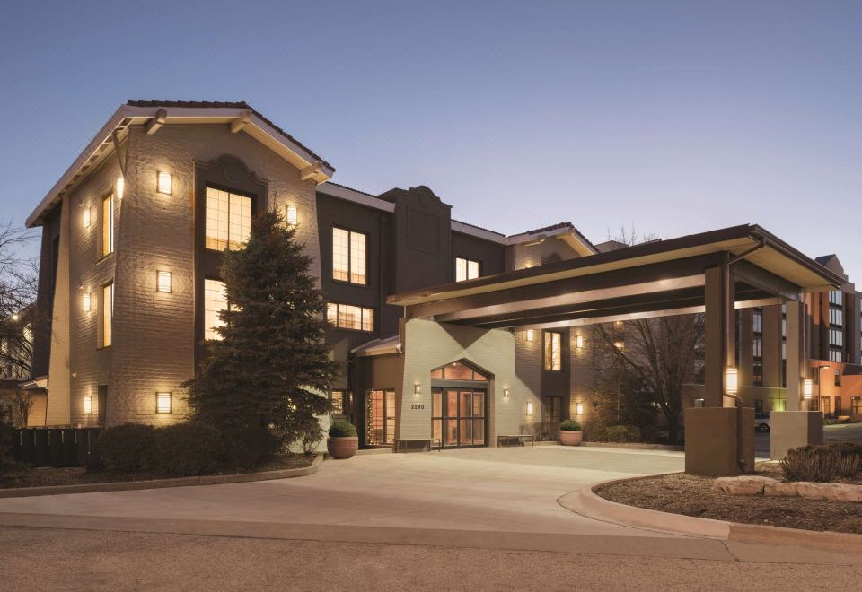 an exterior view of a hotel with a large entrance and a covered walkway leading up to the building at Country Inn & Suites by Radisson, Hoffman Estates, IL