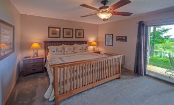 a spacious bedroom with a king - sized bed , multiple lamps , and a fan on the ceiling at Agaming Golf Resort